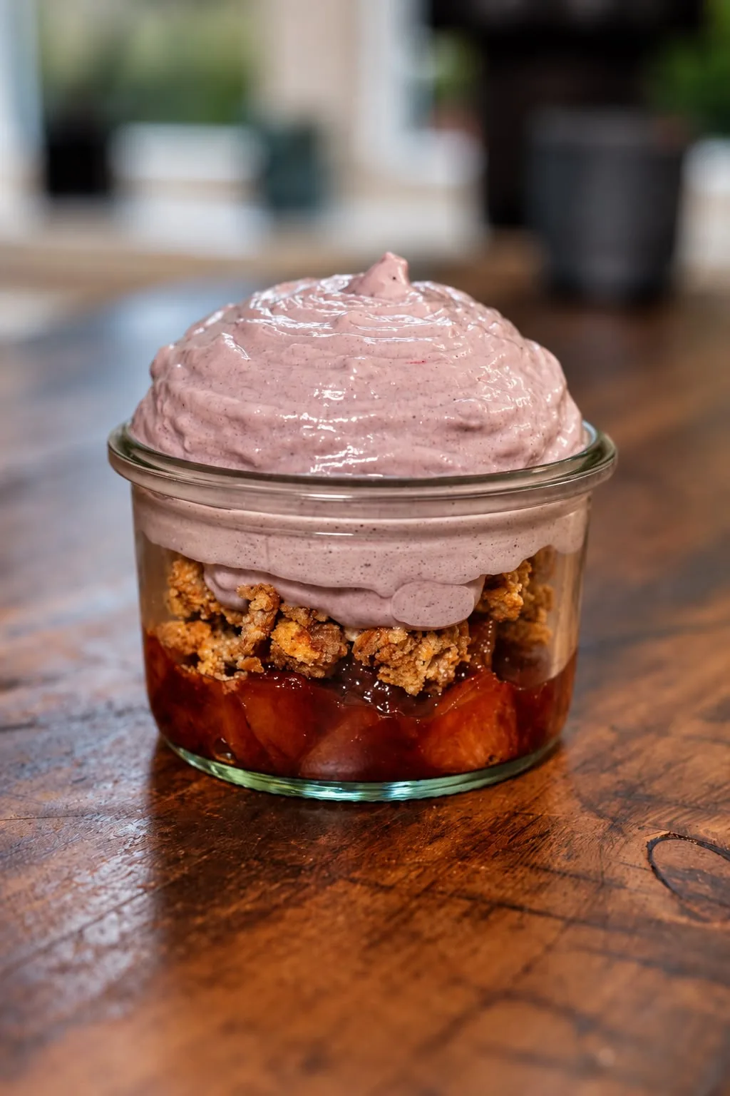 Krümelbecher mit Fruchtkompott, knusprigen Crumble-Streuseln und lila Schaum